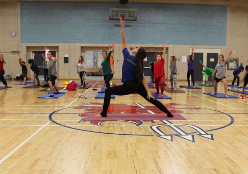 Défi santé - Des personnes font des exercices debout dans un gymnase