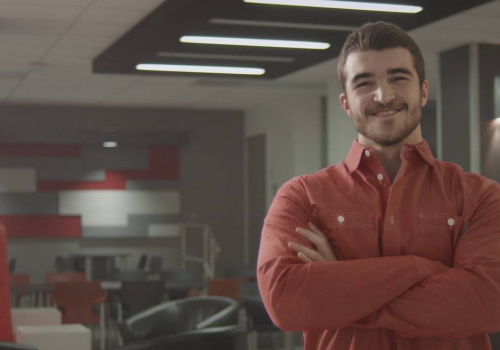 Un homme les bras croisés et souriant