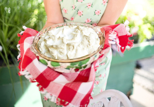 Une tarte à la crème tenue par une femme