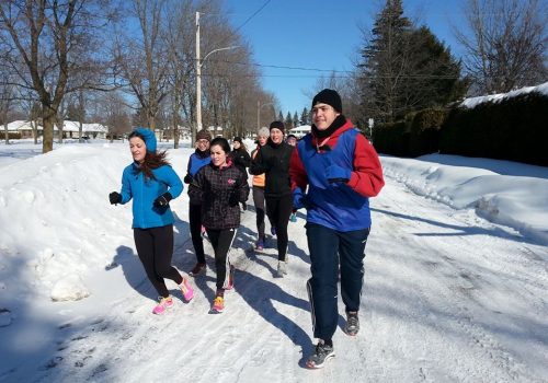 Des coureurs dans un sentier enneigé