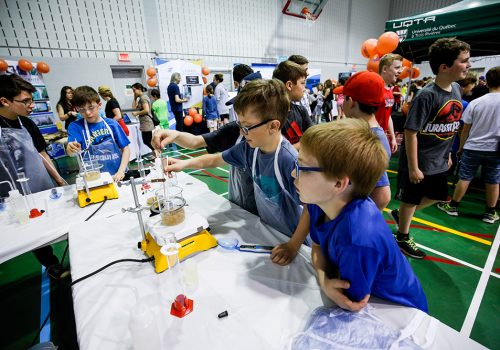 Des jeunes munis d'éprouvettes expérimentent au Salon des Sciences 2018